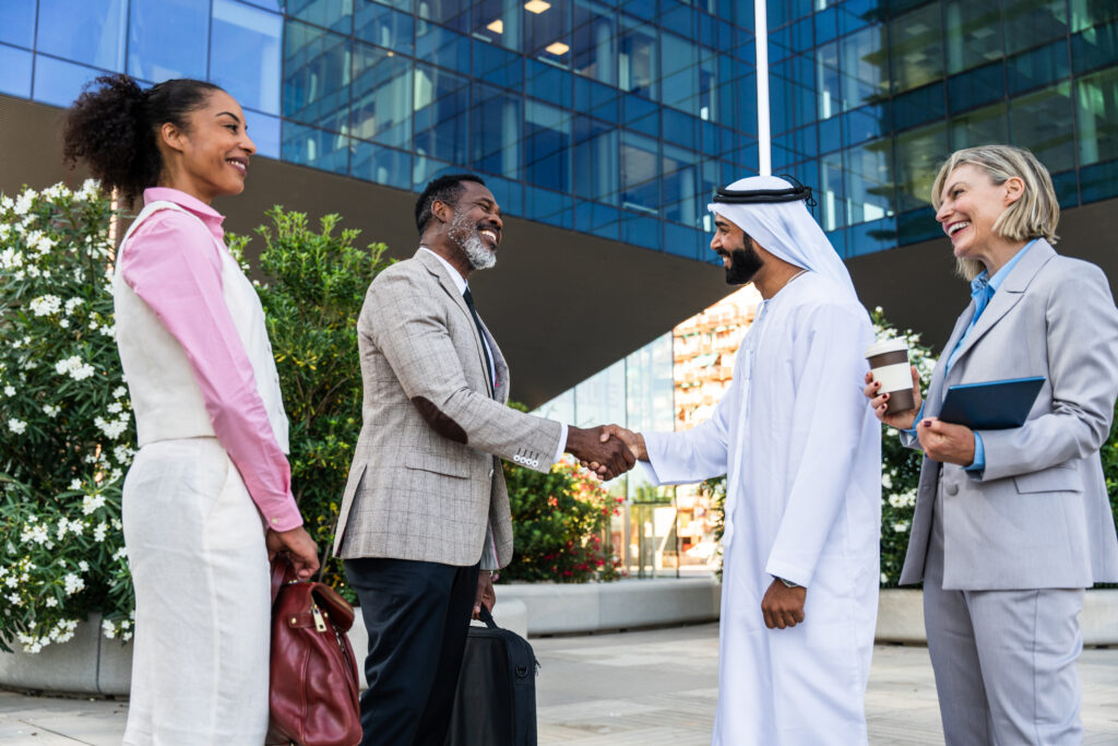 Group of multiethnic business people meeting an emirati businessman - International corporate business team bonding outdoors in the city