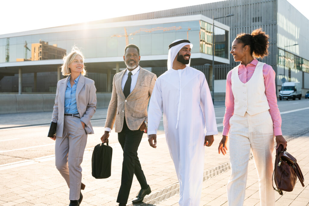 Group of multiethnic business people meeting an emirati businessman - International corporate business team bonding outdoors in the city