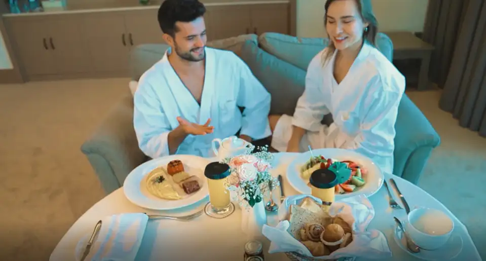 Couple enjoying in-room breakfast at Al Bahar Hotel